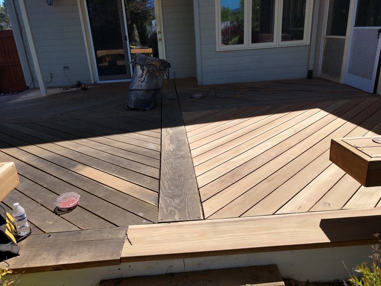 Deck mid-refinish — bare sanded wood beside the old finish
