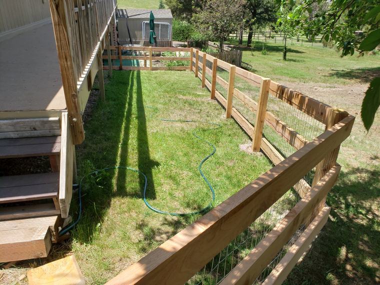 Split-rail and wire fence beside a raised deck